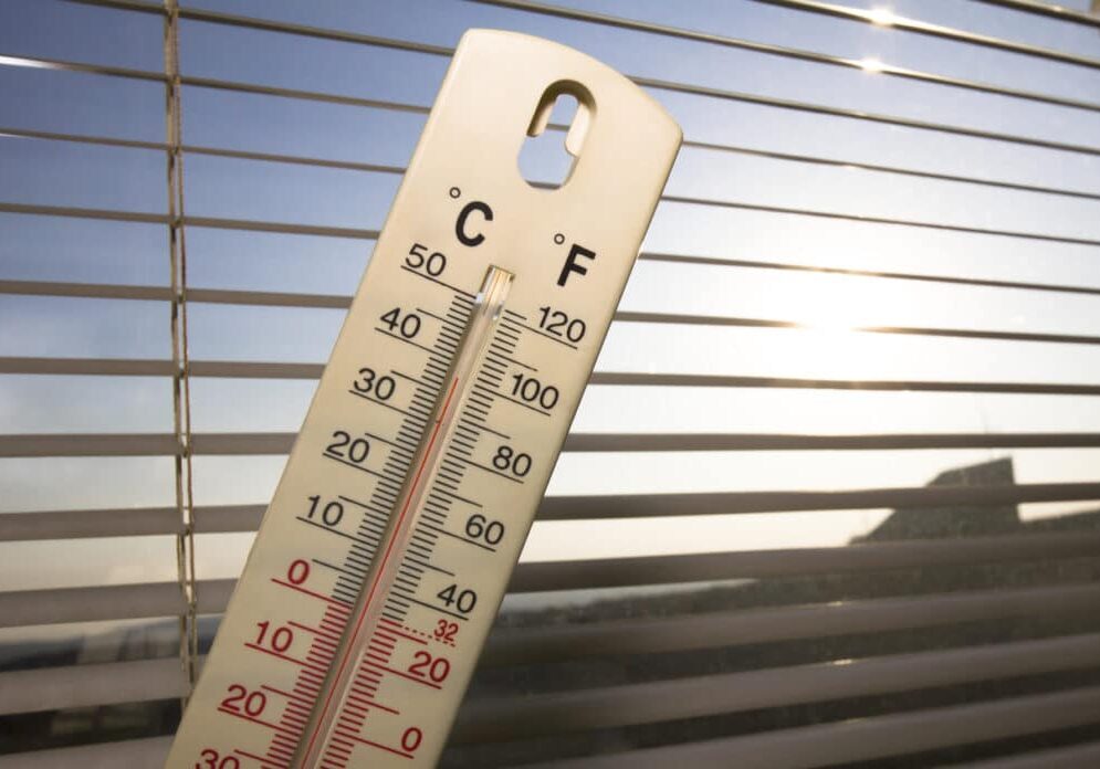 summer heat in the city, shown on mercury thermometer summer heat in the city, shown on mercury thermometer in front of the window, with a 100 degrees Fahrenheit (38 degrees Celsius) and the Sun in the back. photo is taken with DSLR camera.